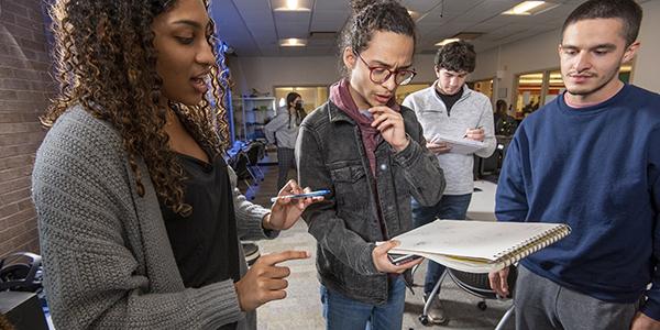 UCNJ students looking at notepad